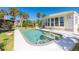Rear exterior view of home featuring a pool, palm trees, and tropical landscaping at 8243 Pinetree Ln, Englewood, FL 34224