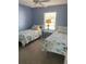 Inviting bedroom features twin beds with beach themed decor creating a cozy space for relaxation and rest at 8937 Bantry Bay Blvd, Englewood, FL 34224