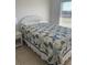 Comfortable bedroom with a patterned quilt, white wicker headboard, and bright natural light from the window at 8937 Bantry Bay Blvd, Englewood, FL 34224