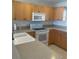 A view of a kitchen with wood cabinets, speckled countertops, and an electric oven at 8937 Bantry Bay Blvd, Englewood, FL 34224