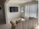 Cozy living room with tile flooring, a large flat-screen TV, and sliding glass doors to the outdoors at 8937 Bantry Bay Blvd, Englewood, FL 34224
