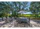 A large, shaded patio features a dining table and seating, offering serene golf course views at 9 Fairway Dr, Englewood, FL 34223