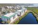 Aerial view of condo buildings surrounded by lush foliage and a tranquil pond at 9203 Griggs Rd # 301, Englewood, FL 34224