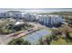 Aerial view of condos, tennis courts, manicured landscaping and a parking area at 9203 Griggs Rd # 301, Englewood, FL 34224