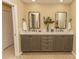 Bathroom showcasing a double vanity with stylish mirrors, neutral walls, and patterned floor accents at 9203 Griggs Rd # 301, Englewood, FL 34224