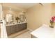 Spacious bathroom with double sinks, marble countertops, decorative rug and warm beige walls at 9203 Griggs Rd # 301, Englewood, FL 34224