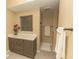 Well-lit bathroom featuring a modern vanity, marble countertop, and a walk-in shower at 9203 Griggs Rd # 301, Englewood, FL 34224