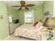Comfortable bedroom featuring green walls, beach themed decor and a ceiling fan at 9203 Griggs Rd # 301, Englewood, FL 34224