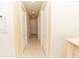 Hallway with multiple closets along a neutral-colored wall, featuring recessed lighting, with a view to a doorway at 9203 Griggs Rd # 301, Englewood, FL 34224