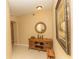 Inviting hallway features stylish decor with tiled floors, decorative table and accent mirror at 9203 Griggs Rd # 301, Englewood, FL 34224