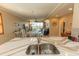 Open-concept kitchen with stainless steel sink, leading to the dining and living area with water views at 9203 Griggs Rd # 301, Englewood, FL 34224