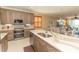 Bright kitchen showcases stone counters, stainless appliances, and a breakfast bar overlooking dining at 9203 Griggs Rd # 301, Englewood, FL 34224