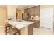 Modern kitchen with breakfast bar, stainless steel refrigerator, tile floors, and stylish cabinetry at 9203 Griggs Rd # 301, Englewood, FL 34224