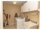 Functional laundry room with washer, dryer, utility sink, overhead cabinets and storage space at 9203 Griggs Rd # 301, Englewood, FL 34224
