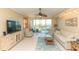 Inviting living room with a ceiling fan, plush seating, and a sliding door leading to a balcony at 9203 Griggs Rd # 301, Englewood, FL 34224
