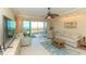 Cozy living room with ceiling fan and sliding glass doors leading to a screened balcony with water views at 9203 Griggs Rd # 301, Englewood, FL 34224