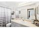 Well-lit bathroom with a large vanity, neutral tile, and shower-tub combination at 118 Albatross Rd, Rotonda West, FL 33947