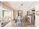 Open dining area with checkered tablecloth, view to the kitchen, and sliding glass doors to the patio at 118 Albatross Rd, Rotonda West, FL 33947