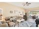 Comfortable living room with neutral decor, ceiling fan, and sliding glass doors to the lanai at 118 Albatross Rd, Rotonda West, FL 33947