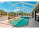 Inviting pool area enclosed by a screened-in lanai with lush landscaping at 118 Albatross Rd, Rotonda West, FL 33947