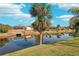 Waterfront property with lush green lawn and mature palm trees at 118 Albatross Rd, Rotonda West, FL 33947