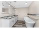 Bathroom featuring dual sinks, granite countertop, and a modern freestanding bathtub at 1313 Buereau Rd, Englewood, FL 34223