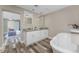 Modern bathroom featuring double sinks, granite countertops, soaking tub, and wood-look flooring at 1313 Buereau Rd, Englewood, FL 34223