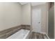 Bathroom featuring a soaking tub, shower, door to hall and wood-look flooring at 1313 Buereau Rd, Englewood, FL 34223