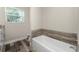 Bathroom featuring a soaking tub, wood-look tile, and natural light at 1313 Buereau Rd, Englewood, FL 34223