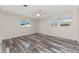 Bright, empty bedroom with wood-look floors and natural light from two windows at 1313 Buereau Rd, Englewood, FL 34223