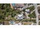 Aerial view of a property featuring a metal roof, lush landscaping, and a pool, showcasing its expansive outdoor space at 1320 Bayshore Dr, Englewood, FL 34223