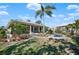 Lush backyard with a screened lanai, a palm tree, a water feature, and tropical landscaping at 1320 Bayshore Dr, Englewood, FL 34223