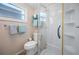 Compact bathroom featuring a toilet and shower stall, plus a window for natural light at 1320 Bayshore Dr, Englewood, FL 34223