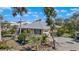 Stunning home with a metal roof, blue shutters, and lush tropical landscaping, creating a serene and inviting atmosphere at 1320 Bayshore Dr, Englewood, FL 34223