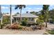 Beautiful home with a metal roof, blue shutters, and lush tropical landscaping, creating a serene and inviting atmosphere at 1320 Bayshore Dr, Englewood, FL 34223