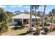 Charming home with a metal roof, blue shutters, and lush tropical landscaping, creating a serene and inviting atmosphere at 1320 Bayshore Dr, Englewood, FL 34223