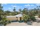 Aerial view of home with a metal roof, palm trees, and gravel landscaping in a serene, wooded setting at 1320 Bayshore Dr, Englewood, FL 34223