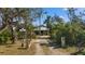 Inviting front entrance with a gravel driveway, decorative lamp post, and lush greenery, creating a charming curb appeal at 1320 Bayshore Dr, Englewood, FL 34223