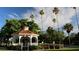 Relaxing park with a gazebo surrounded by tall palm trees and benches in a lush, green setting at 1320 Bayshore Dr, Englewood, FL 34223