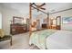 Comfortable main bedroom showcasing a four-poster bed, neutral walls, and bright natural light at 1320 Bayshore Dr, Englewood, FL 34223