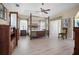 Spacious main bedroom with a four-poster bed, ceiling fan, and wood-look floors at 1320 Bayshore Dr, Englewood, FL 34223