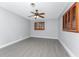 This bedroom features wood-look flooring, a ceiling fan, neutral paint, and wood shuttered windows at 1918 Greenlawn Dr, Englewood, FL 34223