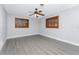 Bright bedroom with hardwood floors, ceiling fan, and windows with custom wooden shutters at 1918 Greenlawn Dr, Englewood, FL 34223