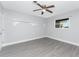 This bedroom features wood-look flooring, neutral paint, a window, and a ceiling fan at 1918 Greenlawn Dr, Englewood, FL 34223