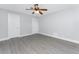 This bedroom features wood-look flooring, neutral paint, two entry doors, and a ceiling fan at 1918 Greenlawn Dr, Englewood, FL 34223