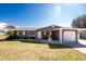 Charming single-story home featuring a well-maintained lawn, neutral paint, and attached garage at 1918 Greenlawn Dr, Englewood, FL 34223