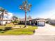 Attractive home featuring a two-car garage, a well-manicured lawn, and mature trees at 1918 Greenlawn Dr, Englewood, FL 34223