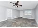 Bright living room with tile flooring, neutral paint, ceiling fan, and entry to walk-in closet at 1918 Greenlawn Dr, Englewood, FL 34223