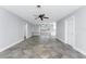 Open living area with tile floor, ceiling fan, and built-in shelving, leading into the kitchen at 1918 Greenlawn Dr, Englewood, FL 34223