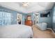 Well-lit bedroom featuring a sitting area, dresser, and TV at 194 Sunset Rd, Rotonda West, FL 33947